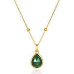 Gold necklace with a green malachite teardrop pendant on a white background