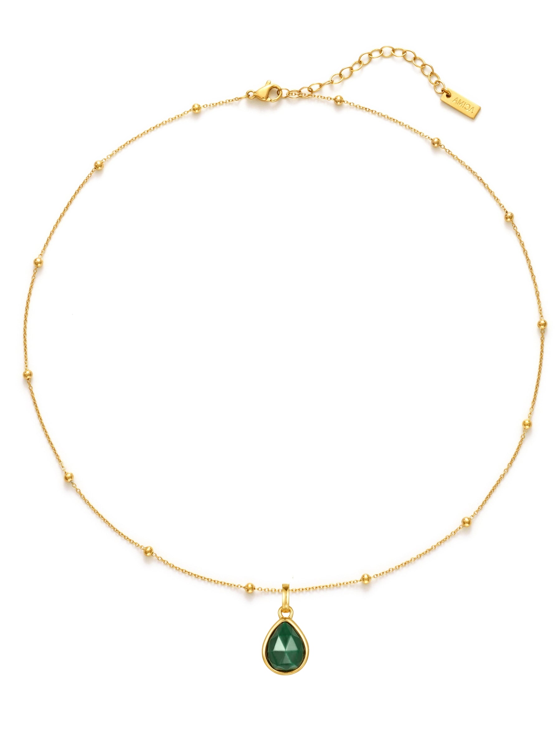 Gold necklace with a green teardrop pendant on a white background