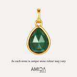 Gold pendant with a green gemstone on a light gray background, featuring the AMICA Jewels brand.