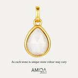 Gold pendant with a white stone on a light beige background, featuring the AMICA Jewels brand.