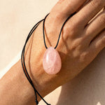 Rose Quartz pendant necklace resting on a model hand