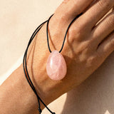 Rose Quartz pendant necklace resting on a model hand