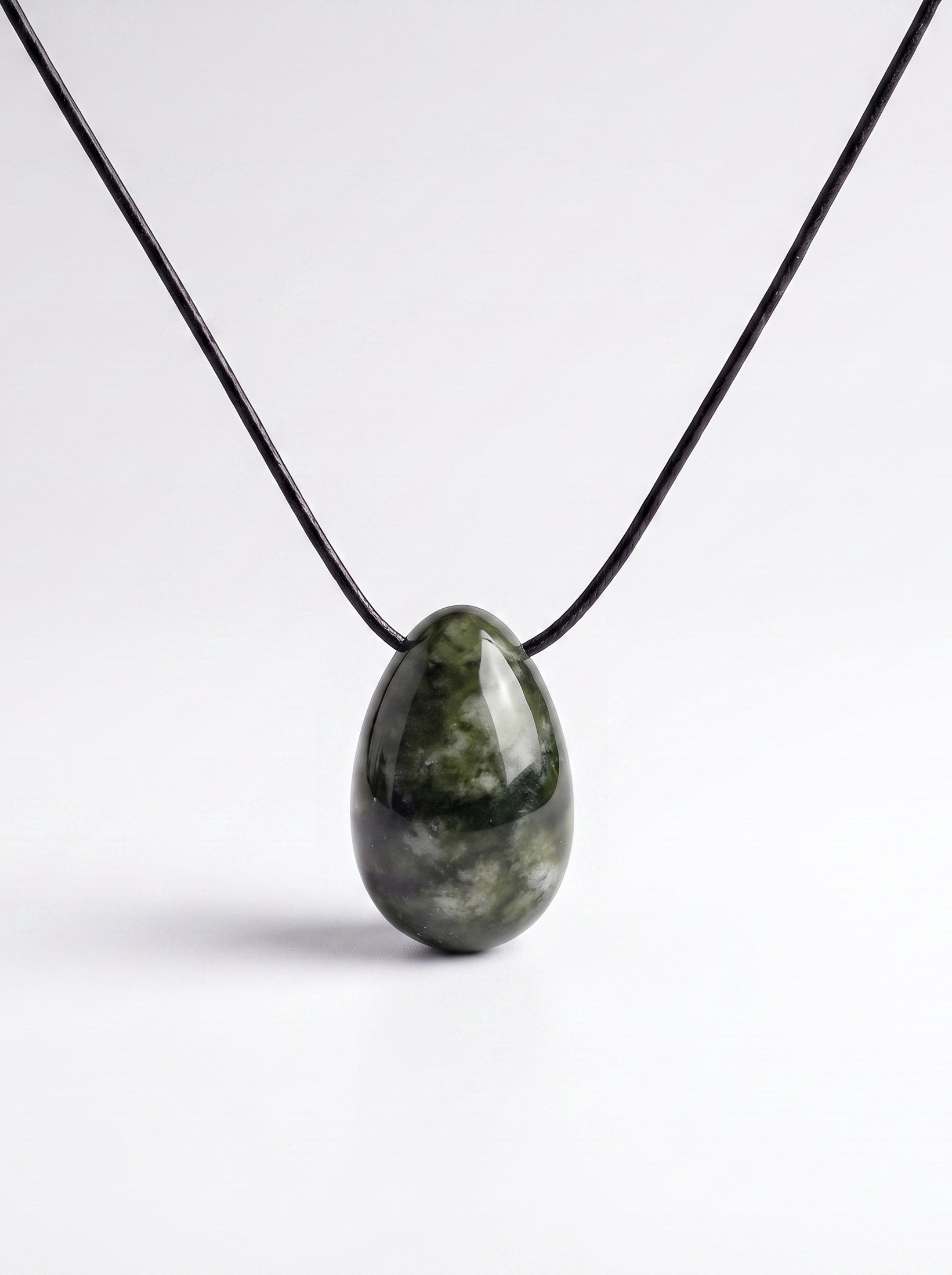 Dark green Southern Chinese Jade egg-shaped pendant on an adjustable black silk cord