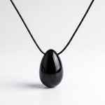 Black Obsidian egg-shaped pendant necklace photographed on a white background