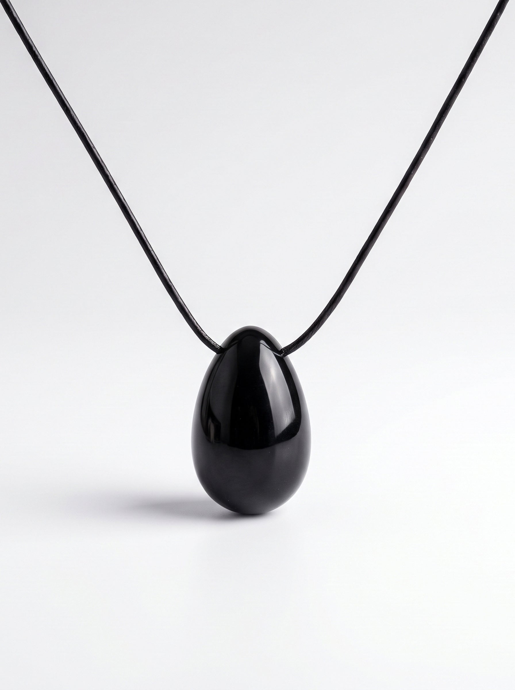 Black Obsidian egg-shaped pendant necklace photographed on a white background