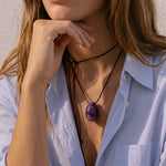 Amethyst egg-shaped pendant on an adjustable black silk cord
