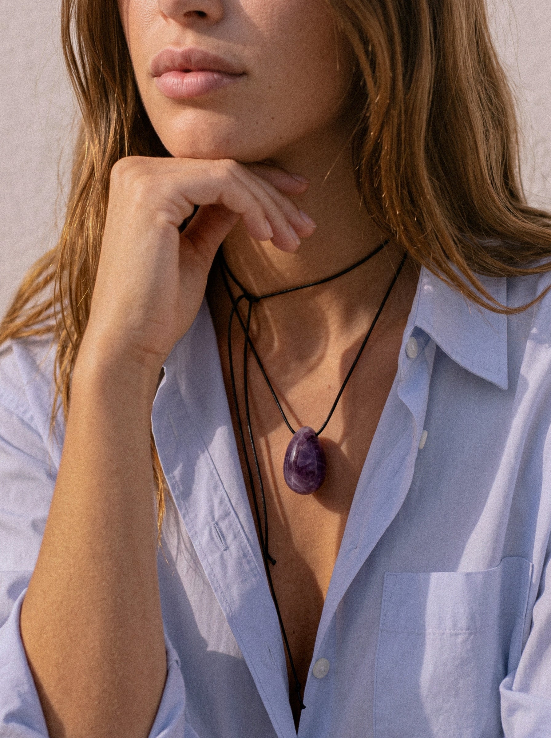 Amethyst egg-shaped pendant on an adjustable black silk cord