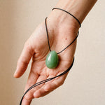 Green Aventurine egg-shaped pendant necklace displayed in an open hand