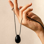Black Obsidian pendant and long adjustable black cord displayed by hand
