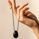 Black Obsidian pendant and long adjustable black cord displayed by hand