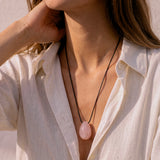 Model wearing a Rose Quartz pendant with layered black cord styling