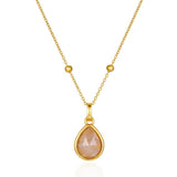 Gold necklace with a teardrop-shaped peach-colored gemstone on a white background