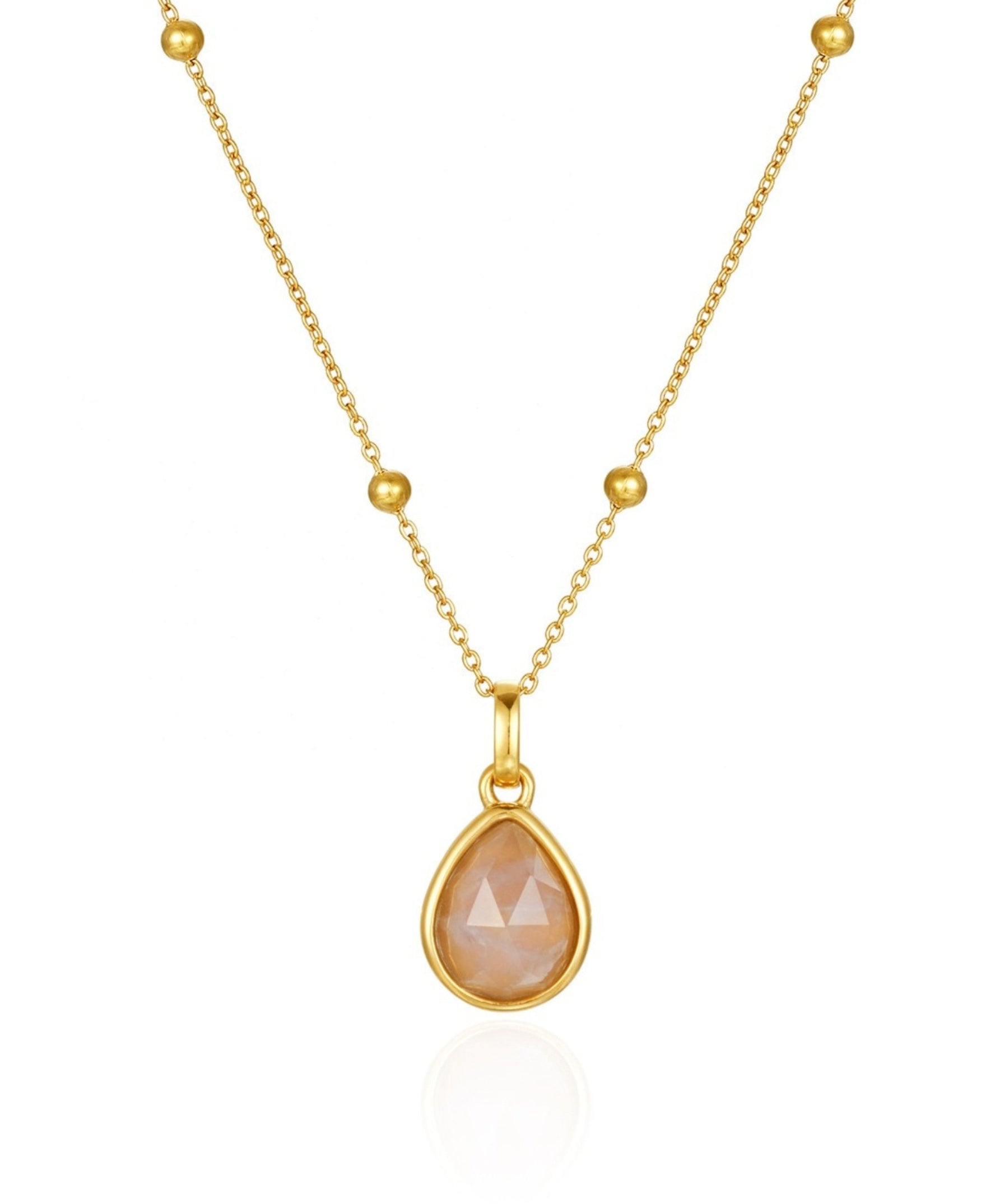 Gold necklace with a teardrop-shaped peach-colored gemstone on a white background