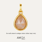 Gold pendant with a teardrop-shaped stone on a light beige background, featuring the AMICA Jewels brand.