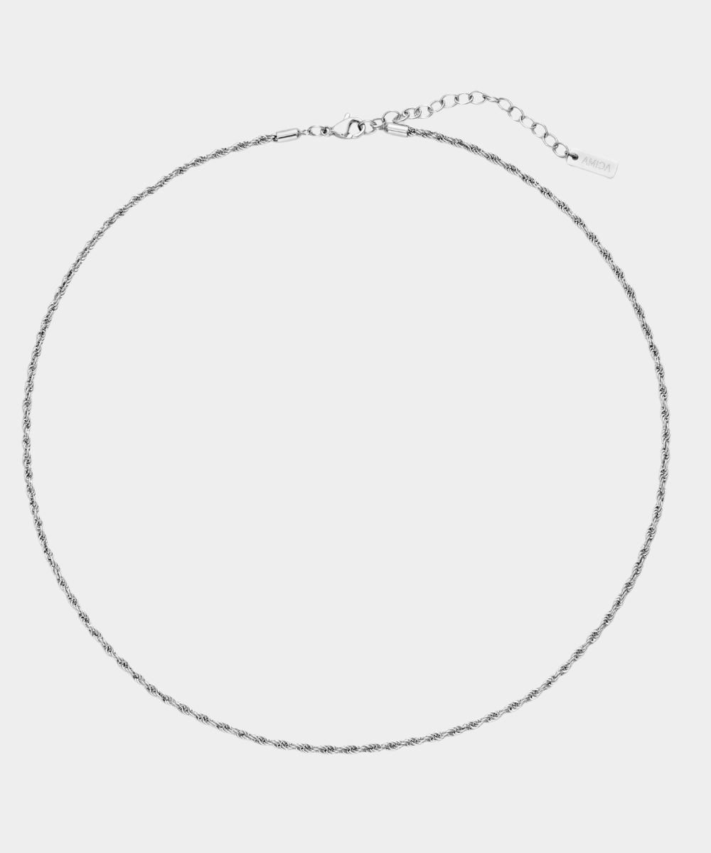 Thin silver necklace on a light gray background