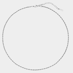 Thin silver necklace on a light gray background