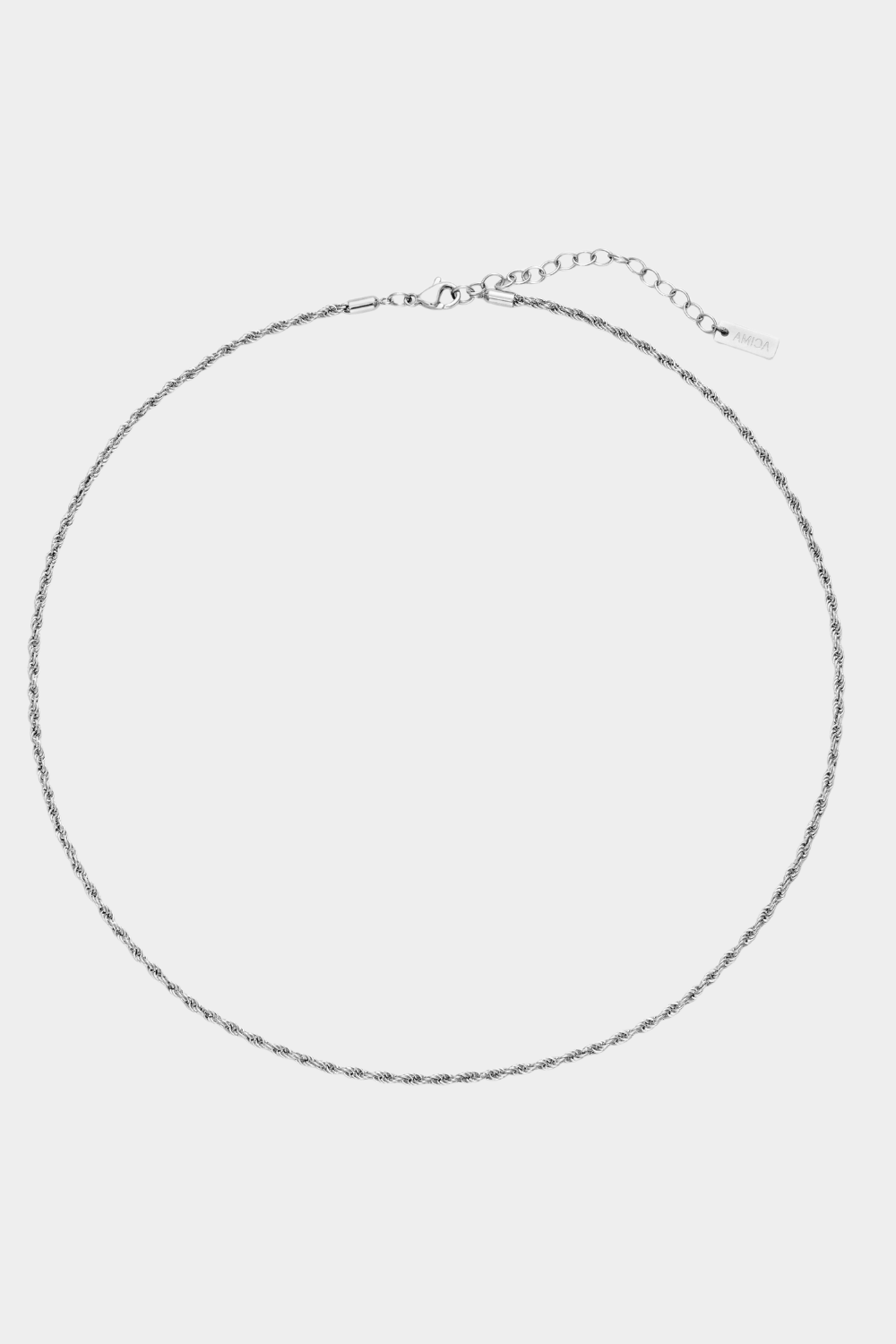 Thin silver necklace on a light gray background