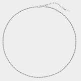 Thin silver necklace on a light gray background