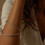 a silver cuff bracelet with a round shape. The bracelet is made entirely of silver, with a smooth and polished finish. This versatile silver cuff bracelet adds a touch of elegance and sophistication to any wrist.