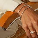 a silver cuff bracelet with a round shape. The bracelet is made entirely of silver, with a smooth and polished finish. This versatile silver cuff bracelet adds a touch of elegance and sophistication to any wrist.